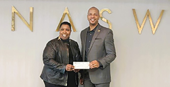 Lawanna Barron, left, hands a check to NASW CEO Anthony Estreet to establish a new student scholarship through the NASW Foundation